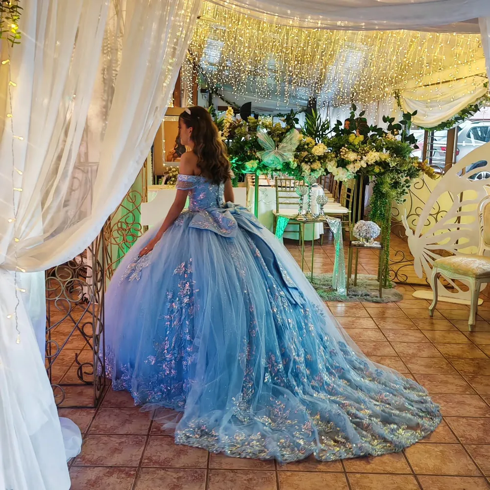 Quinceañera entrando por un arco floral