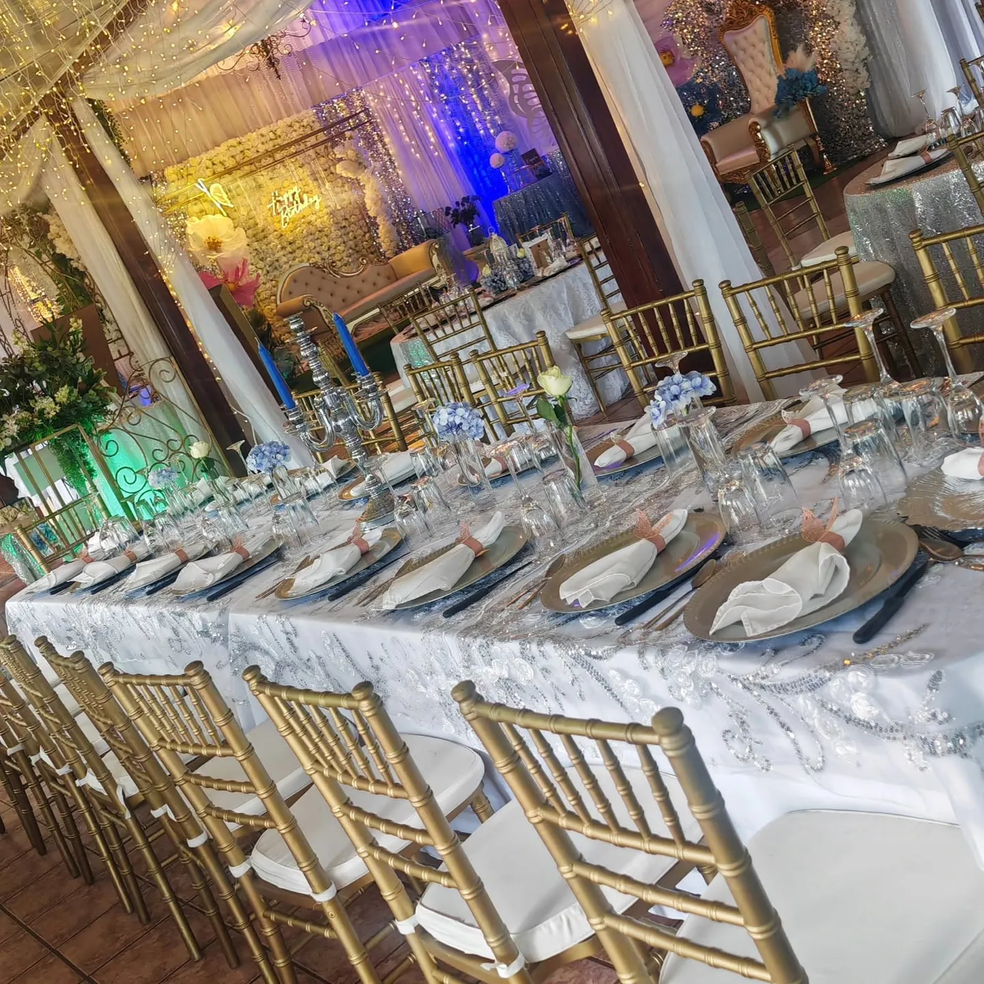 Mesa larga con sillas Chiavari blancas y doradas