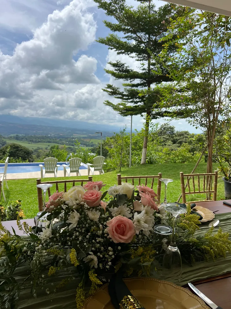 Centro de mesa floral en rosado y blanco con follaje verde
