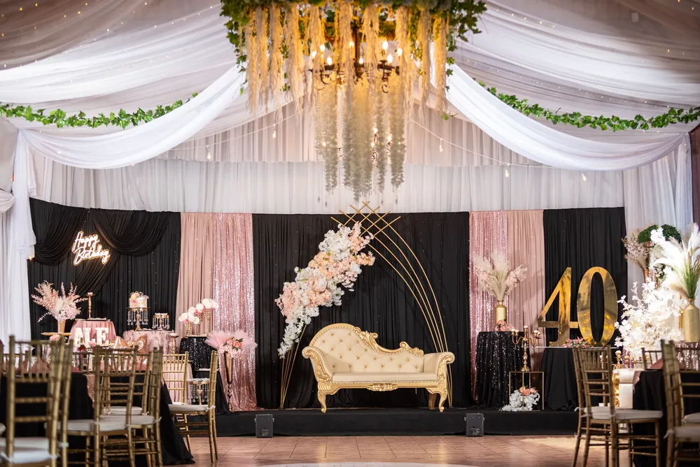 Escenario con candelabro dorado y cortinas blancas