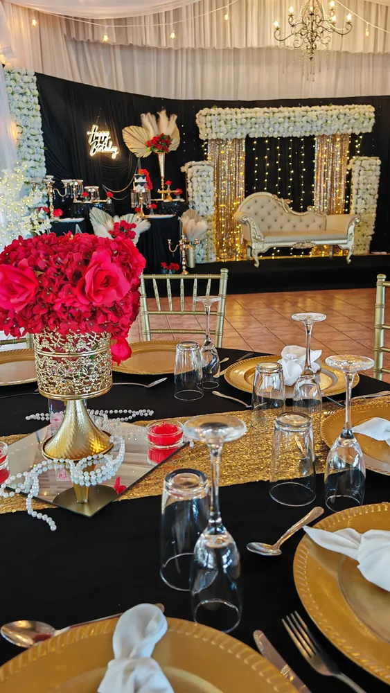 Mesa de cumpleaños en negro y dorado con rosas rojas
